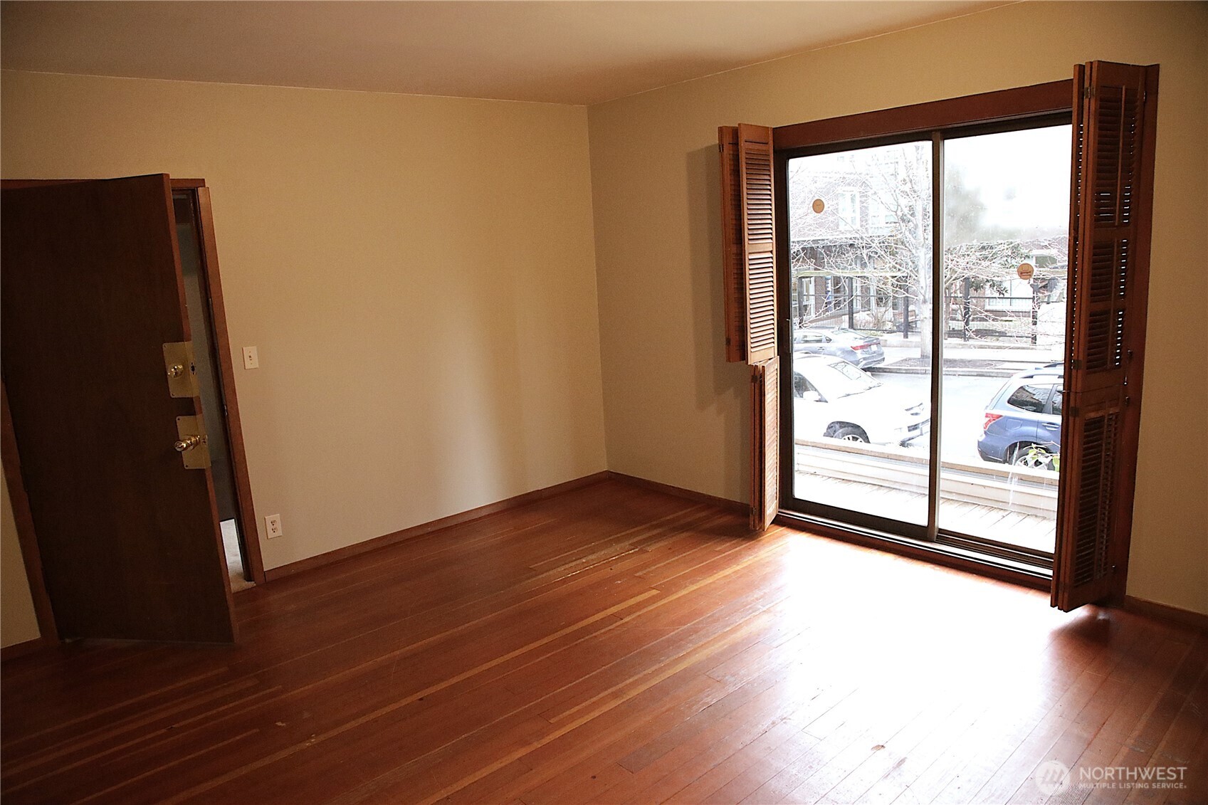 417 Minor Avenue North Seattle, WA 98109 - Photo 18 of 36 an empty room with wooden floor and windows with curtains