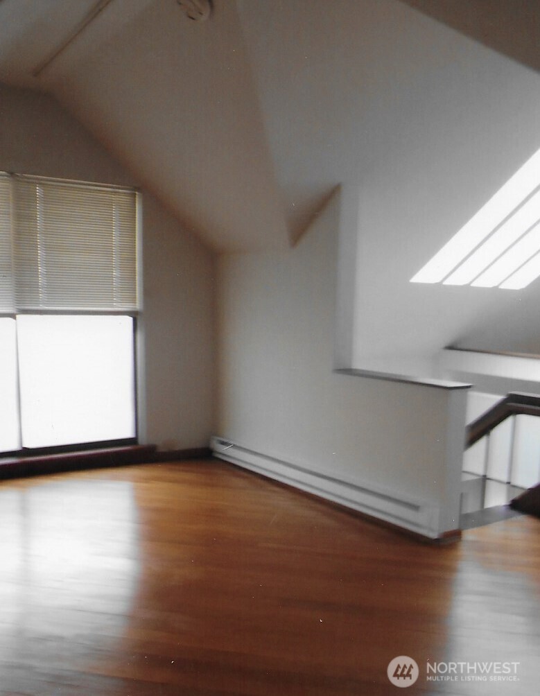 417 Minor Avenue North Seattle, WA 98109 - Photo 29 of 36 a view of an empty room with wooden floor and a window