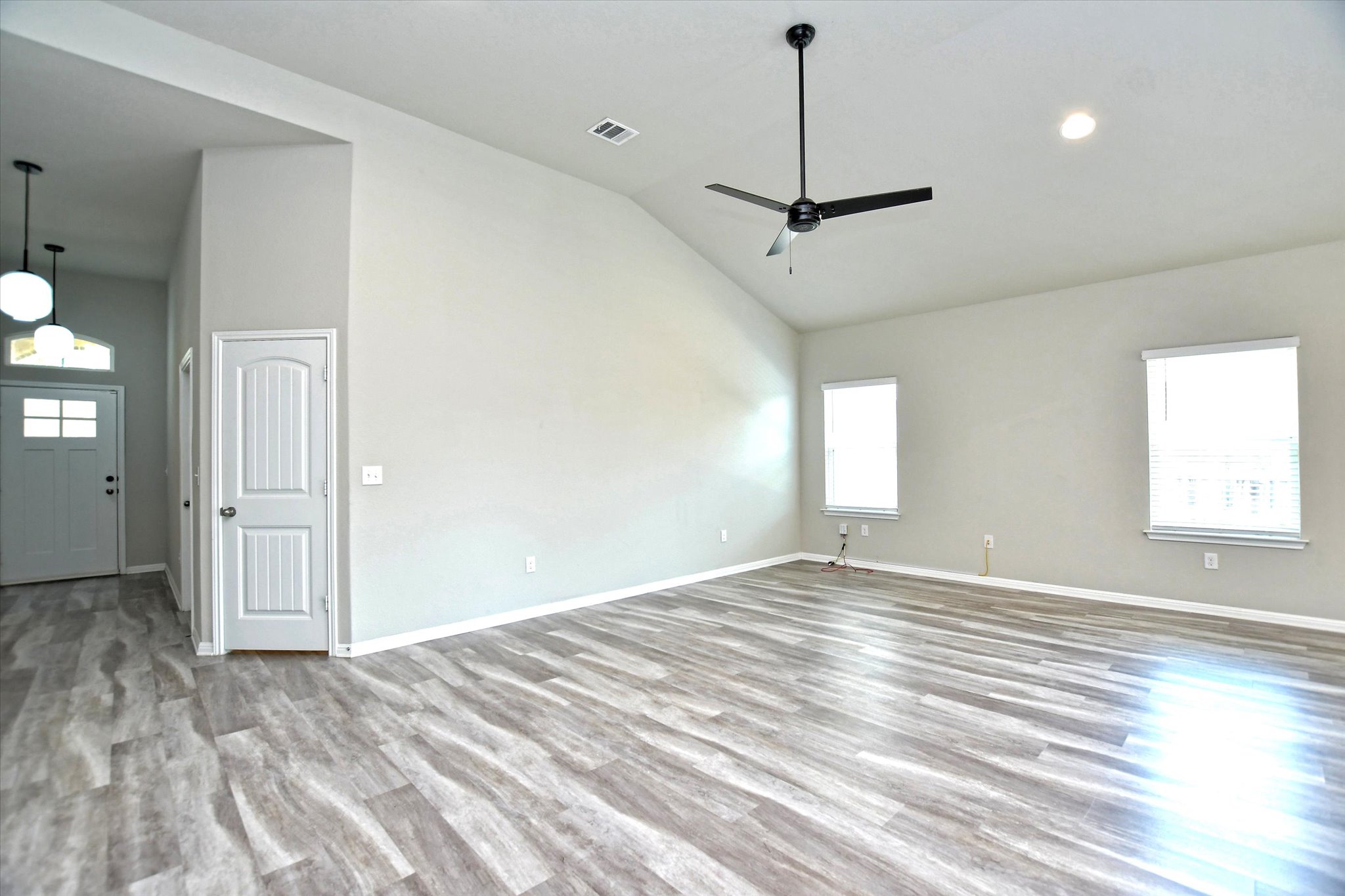 4300 Porter Farm Road Georgetown, TX 78628 - Photo 9 of 36 A spacious living area features vaulted ceilings, abundant natural light, and modern wood flooring.