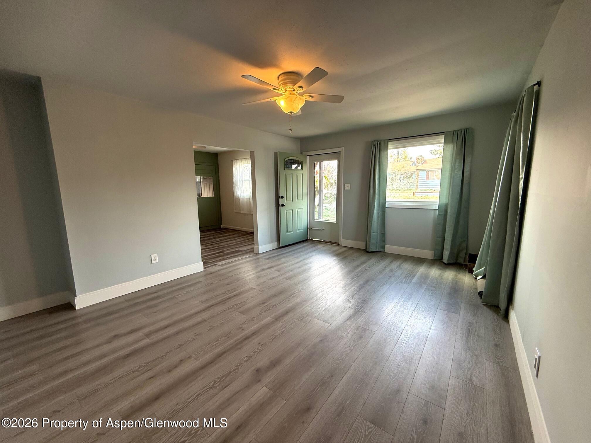 326 Prefontaine Avenue Rifle, CO 81650 - Photo 3 of 12 a view of a livingroom with wooden floor and a ceiling fan
