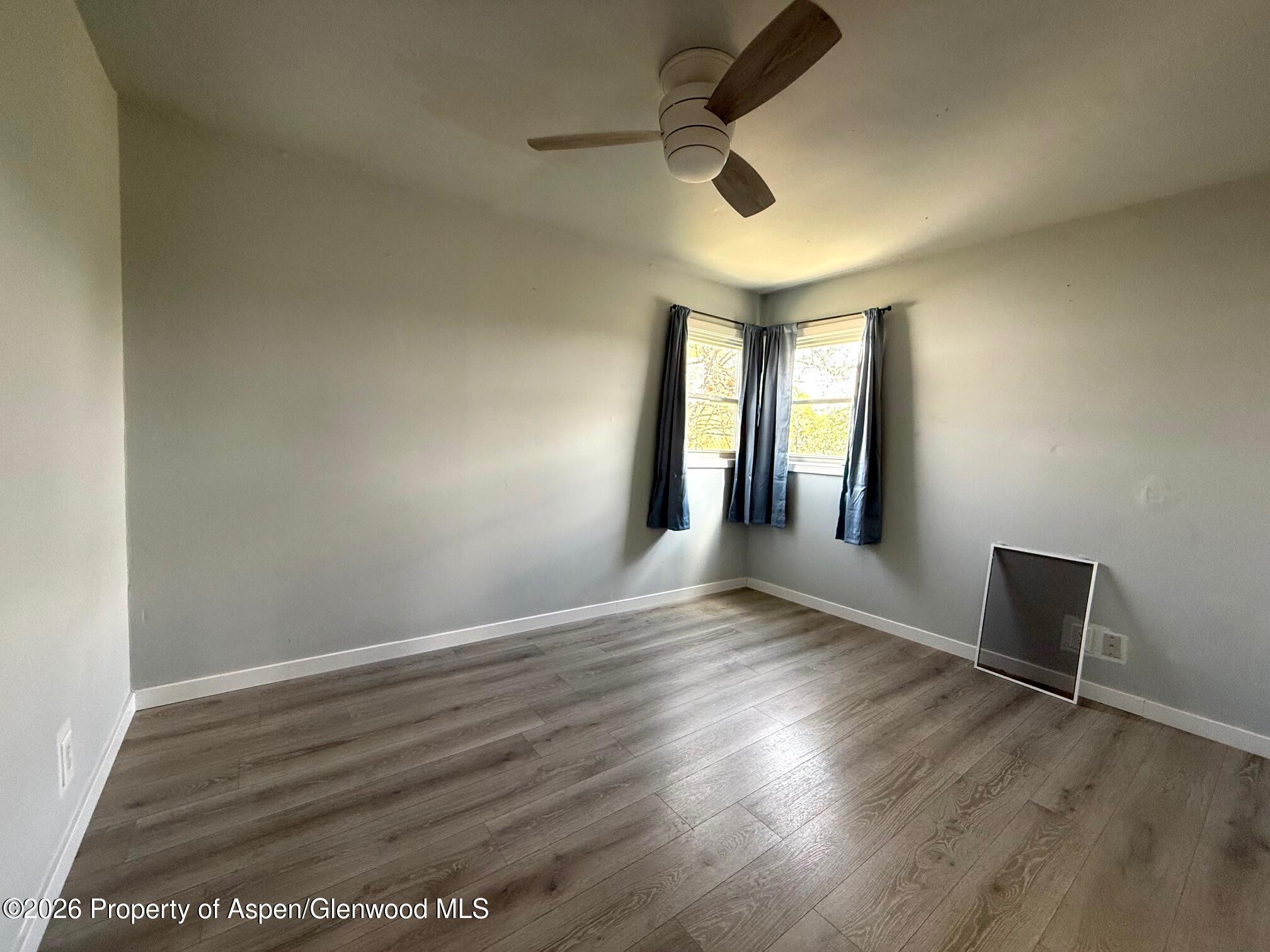 326 Prefontaine Avenue Rifle, CO 81650 - Photo 8 of 12 an empty room with wooden floor and windows