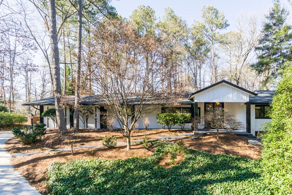 a backyard of a house with table and chairs under an umbrella