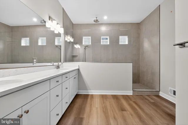 a bathroom with a sink a large mirror and vanity