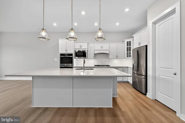 a kitchen with kitchen island a refrigerator a sink and wooden floor