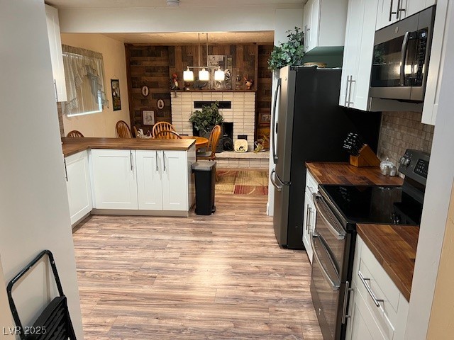 944 Main Street Panaca, NV 89042 - Photo 10 of 24 Kitchen with white cabinetry, hanging light fixtures, light hardwood / wood-style flooring, appliances with stainless steel finishes, and wooden counters