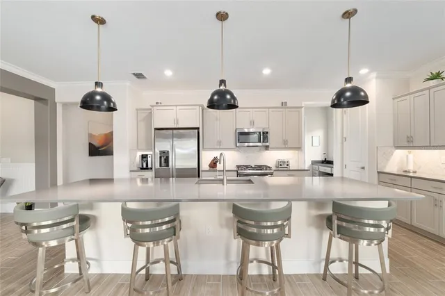 a kitchen with stainless steel appliances a stove a microwave a sink a refrigerator and cabinets