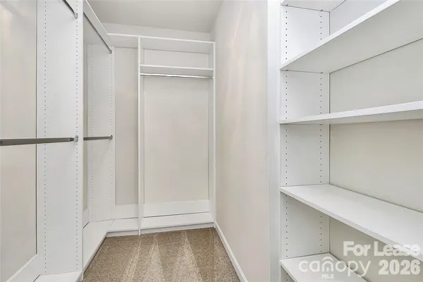 a view of walk in closet with empty racks