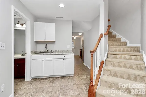 a kitchen with white cabinets and sink