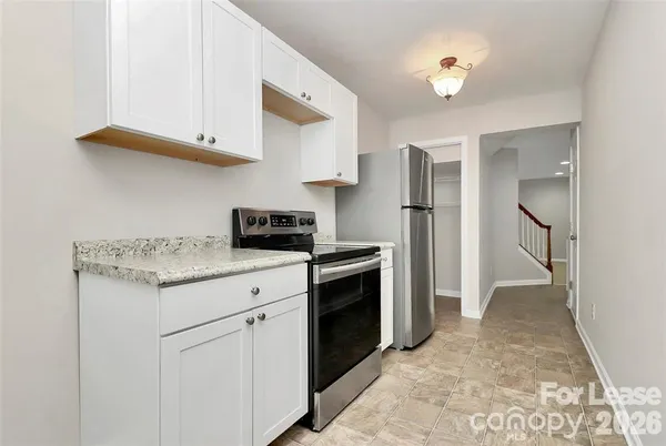 a kitchen with white cabinets and appliances