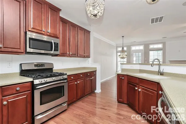 a kitchen with stainless steel appliances granite countertop a stove microwave and cabinets
