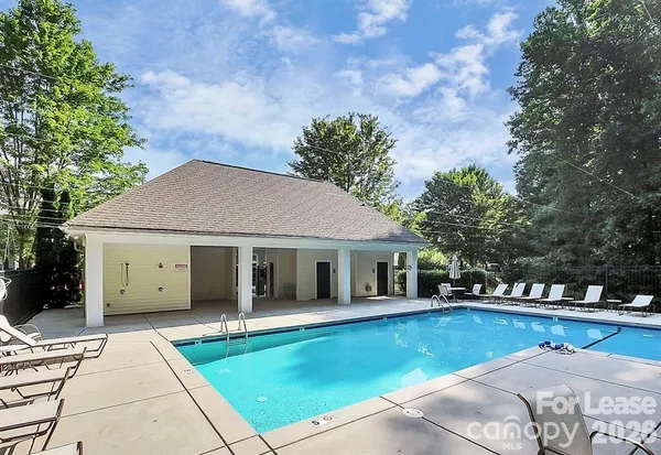 a view of a white house with a swimming pool and a yard