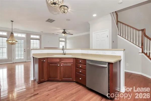 a kitchen with a sink cabinets and wooden floor