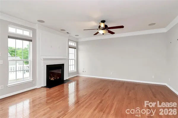 a view of empty room with wooden floor and fireplace