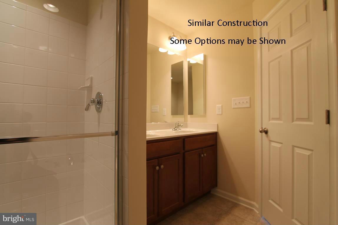 0 Stallion Street, Unit 408 Ranson, WV 25438 - Photo 18 of 30 a bathroom with a double vanity sink mirror and shower