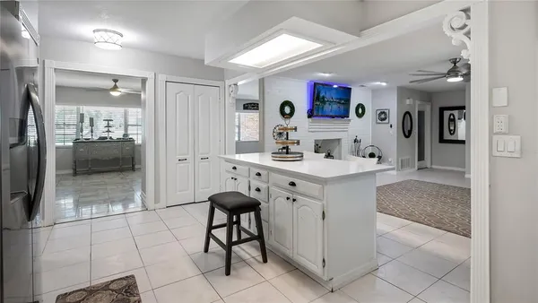 a kitchen with kitchen island a table and refrigerator