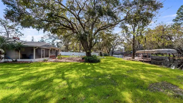 a view of a house with a big yard and large trees