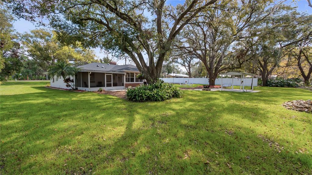 11136 Bronson Road Clermont, FL 34711 - Photo 24 of 29 a view of a house with a big yard and large trees