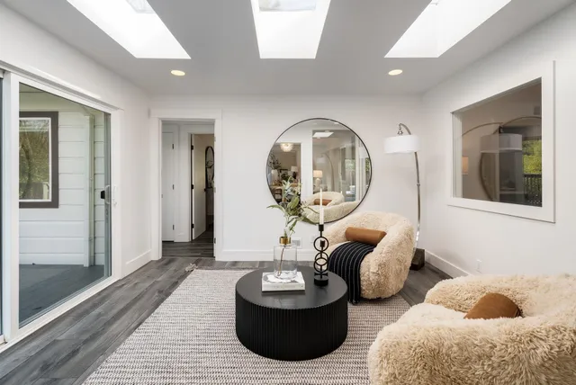 a living room with furniture and a large mirror