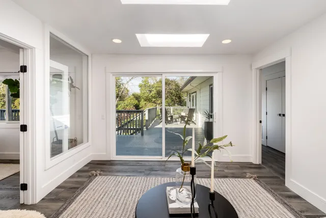 a living room with a floor to ceiling window and wooden floor