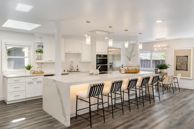a large kitchen with lots of counter space a sink and chairs