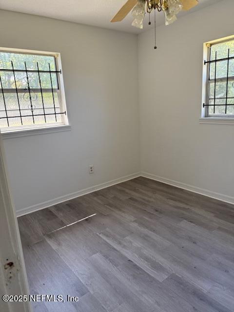 9504 Flechette Avenue Jacksonville, FL 32208 - Photo 11 of 14 an empty room with wooden floor and windows