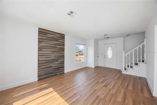 a view of an empty room with stairs and a window