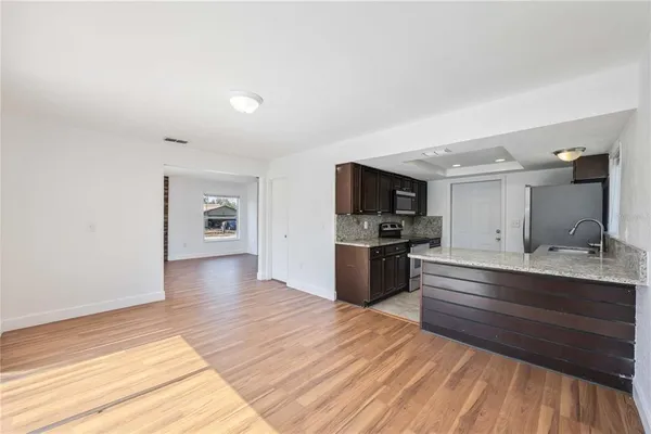 a kitchen with stainless steel appliances kitchen island granite countertop a stove a sink and a refrigerator