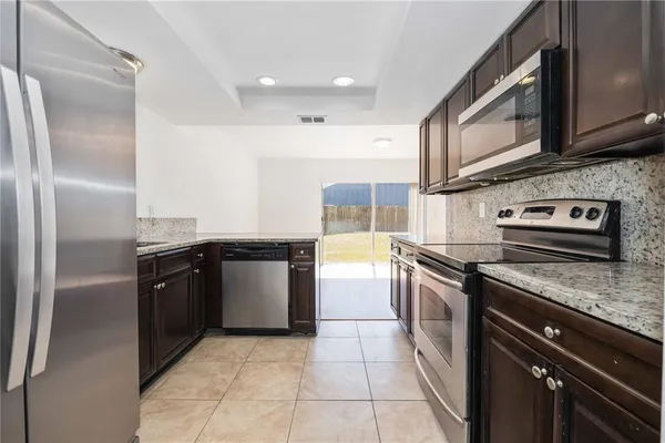 a kitchen with a stove sink and refrigerator