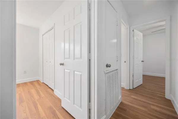 a view of a hallway with wooden floor and closet area