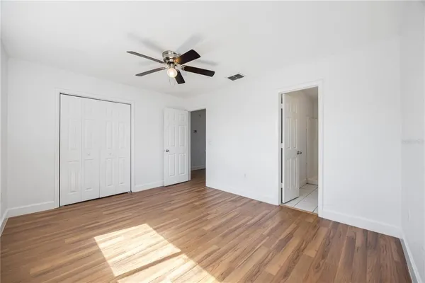 a view of empty room with wooden floor