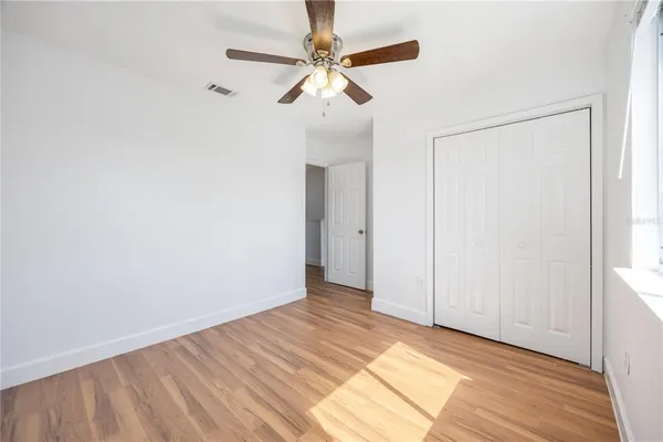 a view of an empty room with wooden floor