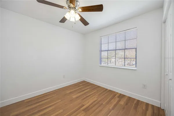 an empty room with a window and a fan