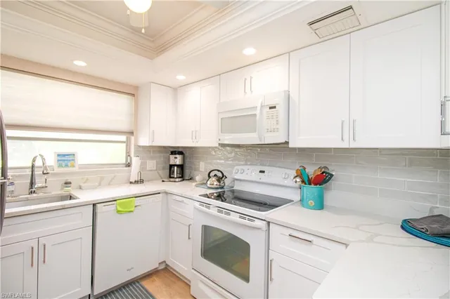 a kitchen with stainless steel appliances white cabinets sink and a stove