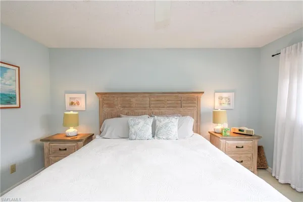 a bedroom with a bed and a lamp on dresser