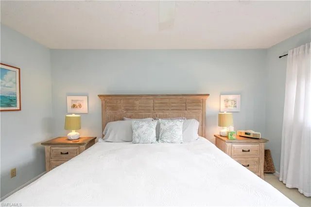 a bedroom with a bed and a lamp on dresser