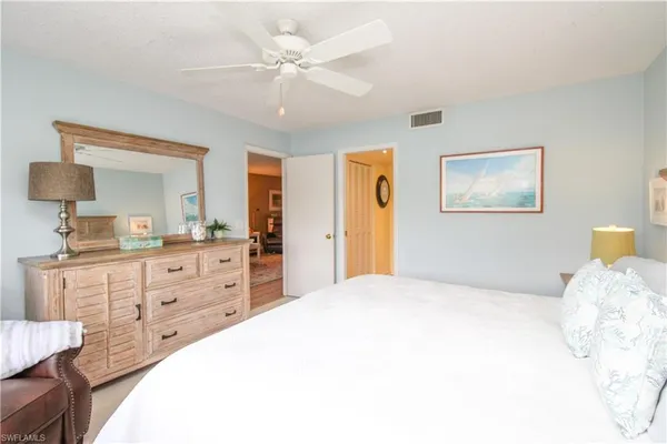 a spacious bedroom with a large bed and a chandelier