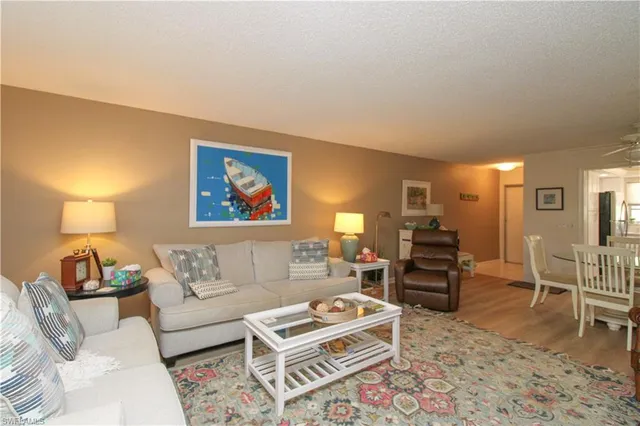 a living room with furniture a rug and a lamp