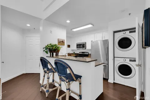 a kitchen with stainless steel appliances granite countertop a stove a refrigerator and a microwave