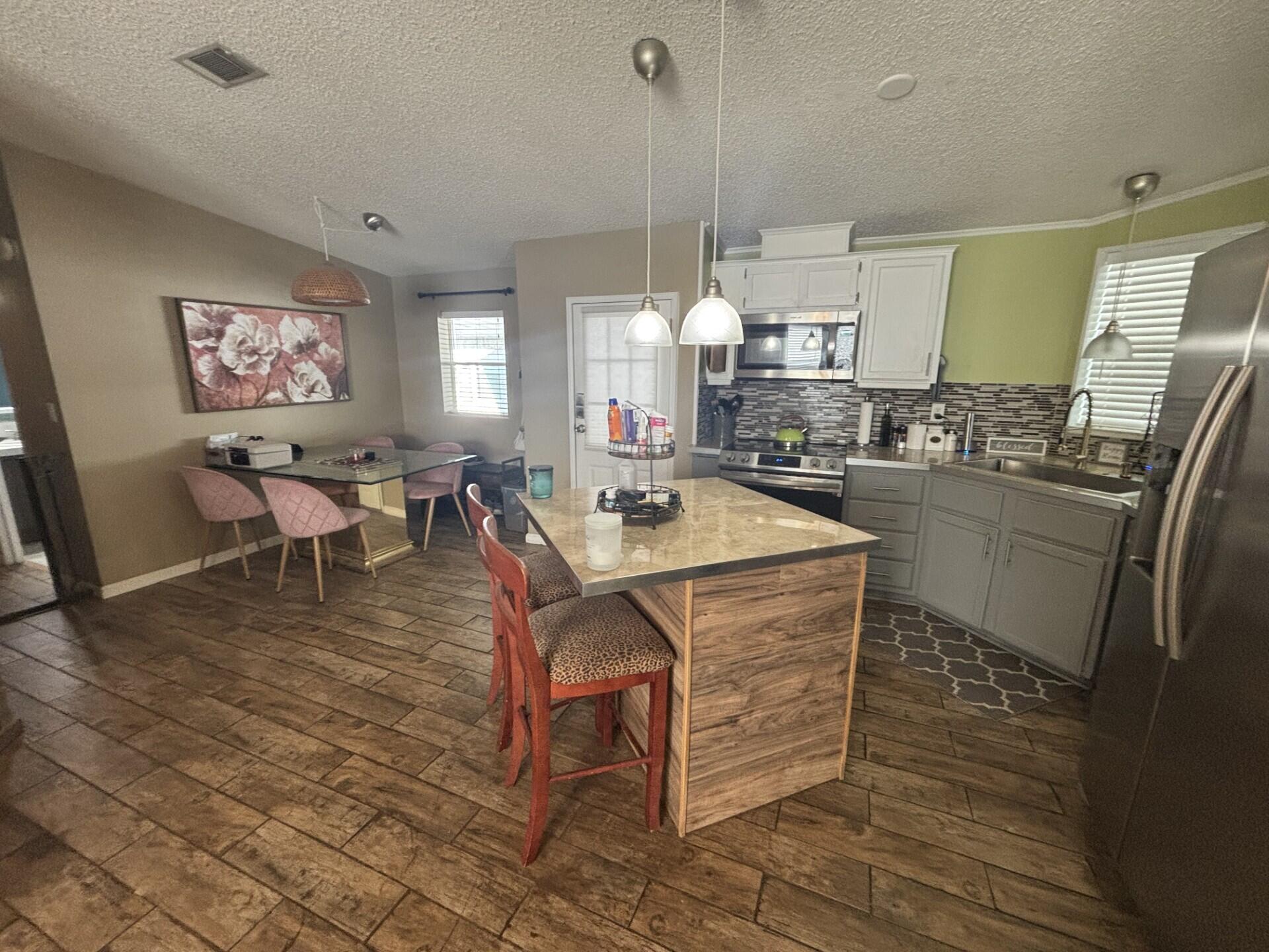 6567 Northwest 34th Avenue Pompano Beach, FL 33073 - Photo 13 of 30 a large kitchen with lots of counter space and stainless steel appliances