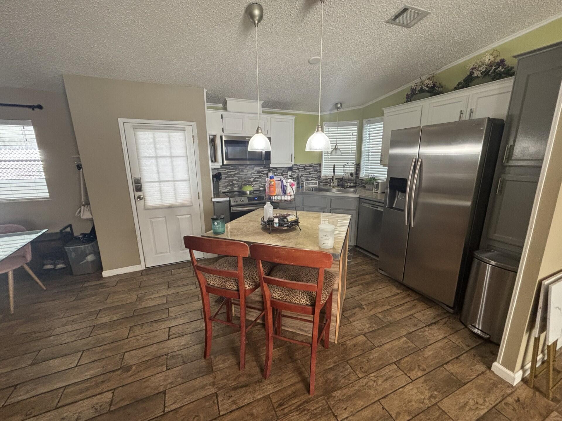 6567 Northwest 34th Avenue Pompano Beach, FL 33073 - Photo 15 of 30 a dining room with furniture a chandelier and wooden floor