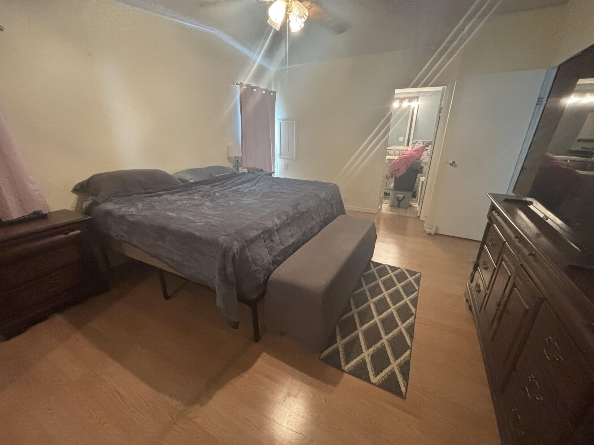 6567 Northwest 34th Avenue Pompano Beach, FL 33073 - Photo 19 of 30 a bedroom with a bed and a chandelier