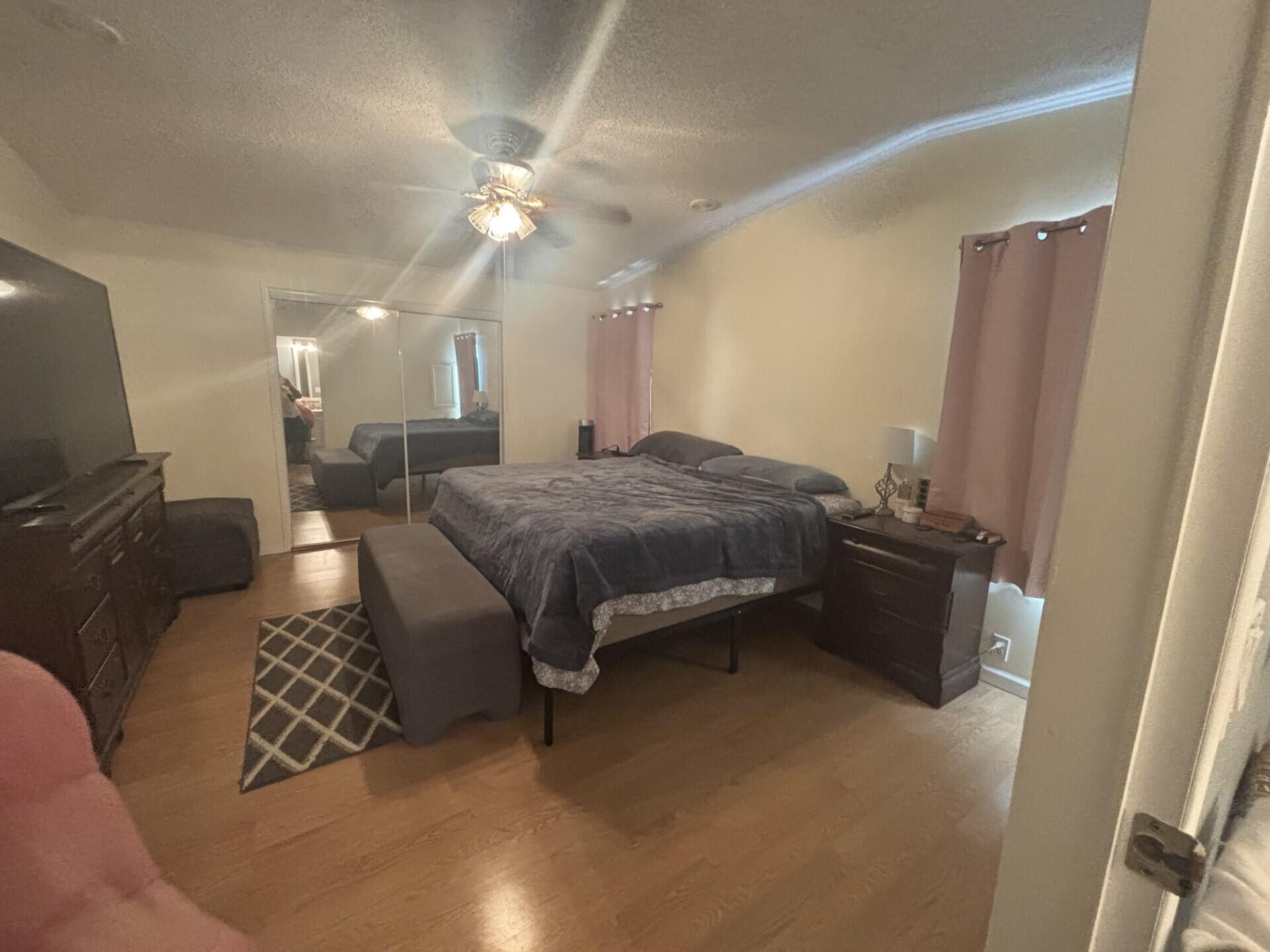 6567 Northwest 34th Avenue Pompano Beach, FL 33073 - Photo 20 of 30 a spacious bedroom with a bed and a chandelier