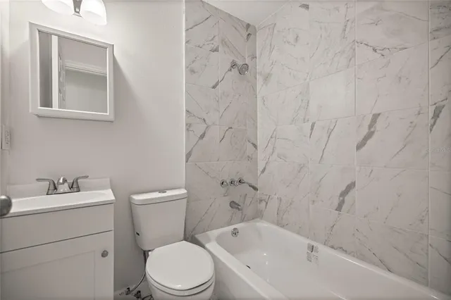 a white toilet sitting next to a bath tub