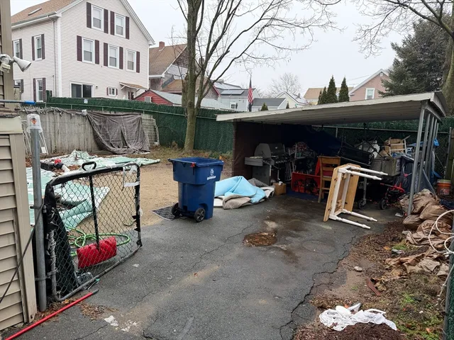 a view of a patio with table and chairs and a barbeque