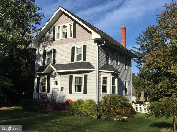 a front view of a house with a yard and trees