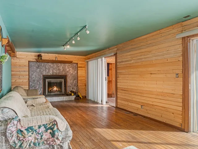 a view of a livingroom with wooden floor and a fireplace