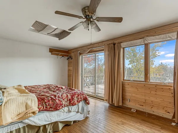 a bedroom with a bed chandelier and a window