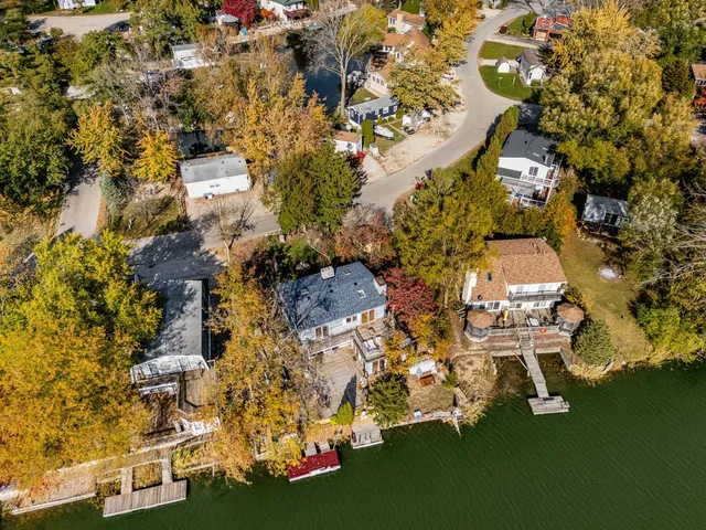 a aerial view of a house with swimming pool lawn chairs and a fire pit