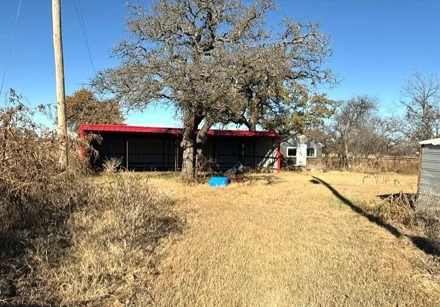 a view of a house with a yard and tree s