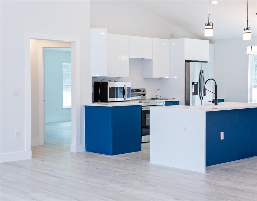 16645 Southwest 59th Court Road Ocala, FL 34473 - Photo 8 of 16 a kitchen with kitchen island a sink wooden floor and refrigerator